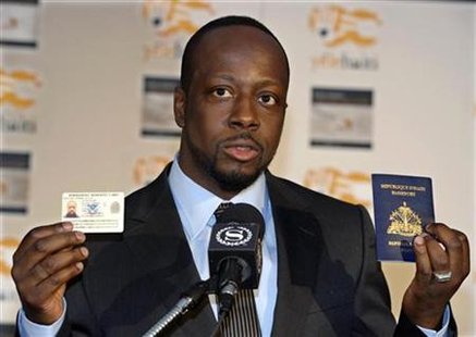
Grammy Award-winning musician Wyclef Jean, a native of Haiti, holds up his U.S. "Green Card" and his Haitian passport as he recounts his experiences after returning from Haiti at a news conference in New York, January 18, 2010. REUTERS/Ray Stubblebine
