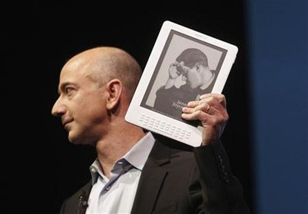 
Amazon.com founder and CEO Jeff Bezos holds the new Kindle DX electronic reader at a news conference where the device was introduced in New York May 6, 2009. REUTERS/Eric Thayer
