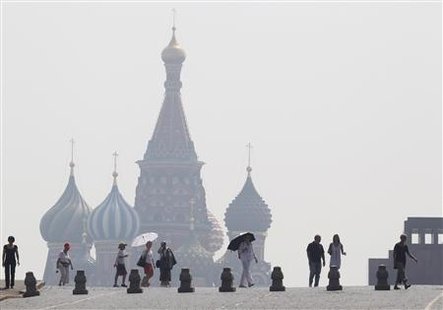 
People walk along Red Square, with St. Basil's Cathedral seen through heavy smog caused by peat fires in out-of-city forests, in Moscow, July 26, 2010. REUTERS/Sergei Karpukhin
