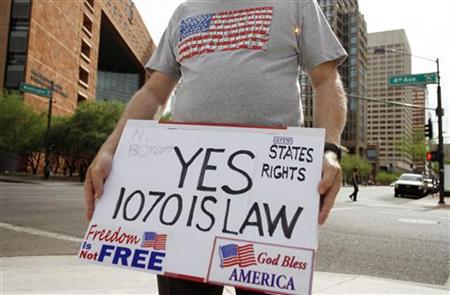 
Larry Templeton holds a sign supporting Arizona's controversial SB1070 immigration law outside the U.S. District Court in Phoenix July 15, 2010. REUTERS/Joshua Lott

