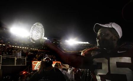 
Alabama Crimson Tides Rolando McClain carries the championship trophy off the field after they defeated the Texas Longhorns in the NCAA's BCS National Championship football game in Pasadena, January 7, 2010. REUTERS/Mike Blake
