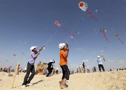 
Palestinian children fly kites on the beach of Beit Lahiya in the northern Gaza Strip during a summer camp organised by the United Nations Relief and Works Agency (UNRWA) July 29, 2010. REUTERS/Mohammed Salem
