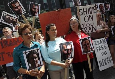 
Laura Fattal (L), Cindy Hickey (C) and Nora Shourd (R), the mothers of Josh Fattal, Shane Bauer, and Sarah Shourd respectively, hold pictures of their children while protesting for their release with others outside the Iran Mission in New York, July 30, 2010. REUTERS/Mike Segar
