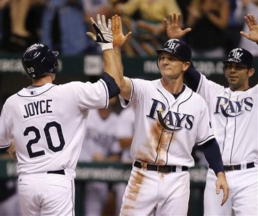 
Tampa Bay Rays' Matt Joyce (L) celebrates with the Ray's John Jaso(C) and Carlos Pena after hitting a three-riun home run against the New York Yankees during the sixth inning of their MLB American League baseball game in St. Petersburg, Florida July 30, 2010. REUTERS/Scott Audette
