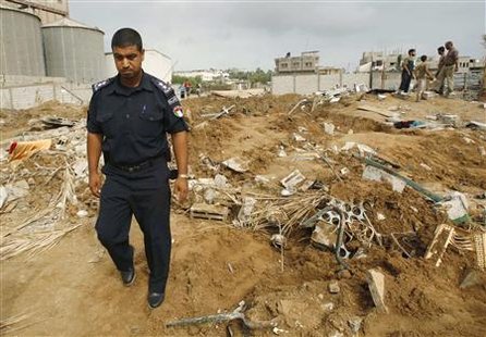 
A Hamas policeman surveys the damage after Israeli air strikes in the central of Gaza Strip July 31, 2010. Israel carried out air strikes on targets in the Gaza Strip on Friday after a rocket fired from the Palestinian territory exploded in the city of Ashkelon, witnesses said. REUTERS/Ibraheem Abu Mustafa
