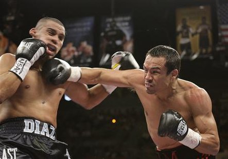 
Juan Diaz (L) of the U.S. takes a punch from Juan Manuel Marquez of Mexico during the WBA/WBO lightweight title fight at the Mandalay Bay Events Center in Las Vegas, Nevada, July 31, 2010. REUTERS/Steve Marcus
