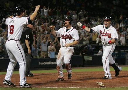 Atlanta Braves runner Brooks Conrad (C) celebrates as he scores the winning run against the Los Angeles Dodgers and is greeted by teammates Brandon Hicks (L) and Eric Hinske (R) in the bottom of the ninth inning of MLB National League action in Atlanta, Georgia August 16, 2010. REUTERS/Tami Chappell
Atlanta Braves runner Brooks Conrad (C) celebrates as he scores the winning run against the Los Angeles Dodgers and is greeted by teammates Brandon Hicks (L) and Eric Hinske (R) in the bottom of the ninth inning of MLB National League action in Atlanta, Georgia August 16, 2010. REUTERS/Tami Chappell
