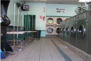 Rows of washing machines and dryers line a laundromat.