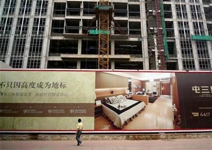 A pedestrian looks up at a billboard advertising luxury apartments currently under construction in central Beijing August 11, 2010. REUTERS/David Gray
A pedestrian looks up at a billboard advertising luxury apartments currently under construction in central Beijing August 11, 2010. REUTERS/David Gray