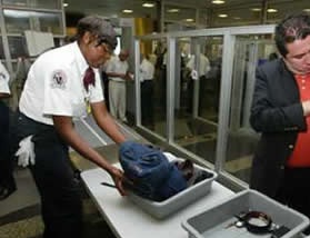 A TSA worker at an airport security check-point. A TSA worker at an airport security check-point.