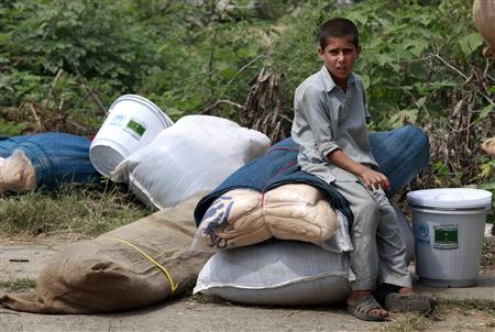 
A flood victim sits on supplies he received from a distribution point set up by the U.N. High Commissioner for Refugees in Charsadda, in Pakistan's northwest Khyber-Pakhtunkhwa Province September 1, 2010. PREUTERS/Faisal Mahmood
