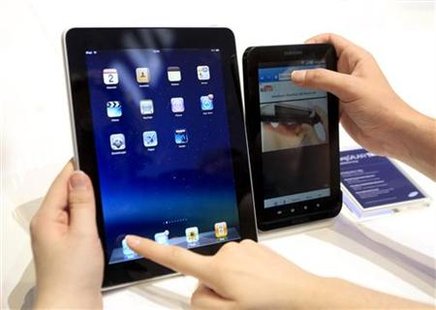 
People compare the performance of Apple's iPad (L) and Samsung's Galaxy Tab tablet devices at the Internationale Funkausstellung (IFA) consumer electronics fair at "Messe Berlin" exhibition centre in Berlin, September 2, 2010. REUTERS/Thomas Peter
