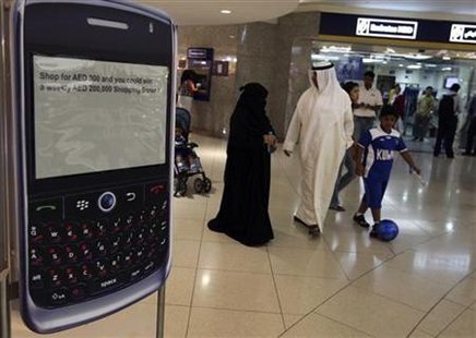 
A family walks past a display of a BlackBerry smart phone at a shopping mall in Dubai August 1, 2010. REUTERS/Mosab Omar
