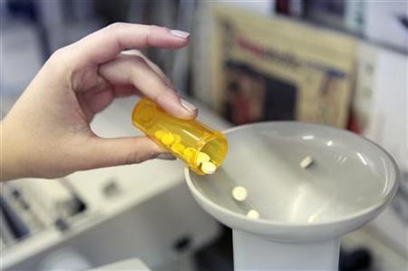 
A pharmacy employee dumps pills into a pill counting machine as she fills a prescription while working at a pharmacy in New York December 23, 2009. REUTERS/Lucas Jackson
