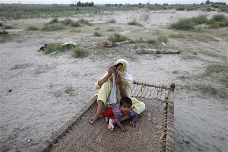 
A Pakistani flood victim covers her face as she talks on the phone at a relief camp for victims in Muzaffargarh district of Punjab province September 3, 2010. REUTERS/Damir Sagolj
