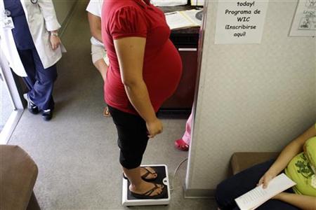 
A pregnant woman stands on a scale before receiving a prenatal exam at the Maternity Outreach Mobile in Phoenix, Arizona October 8, 2009. REUTERS/Joshua Lott
