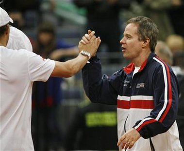 
U.S. team captain Patrick McEnroe (R) congratulates Bob Bryan after winning Davis Cup World group first round doubles tennis match with team mate John Isner against Serbia's Nenad Zimonjic and Janko Tipsarevic in Belgrade March 6, 2010. REUTERS/Ivan Milutinovic

