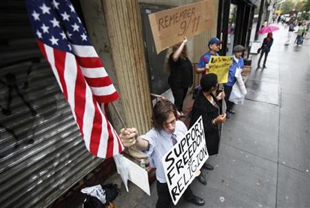 
Demonstrators who support and oppose the proposed Muslim cultural center and mosque Park51 stand with signs in front of the site in New York in this August 25, 2010 file photo. REUTERS/Lucas Jackson
