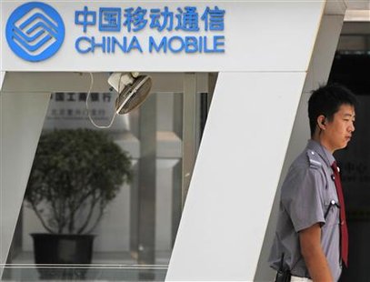 
A security guard stands next to a China Mobile logo outside the China Mobile building in central Beijing September 8, 2010. Shares in China Mobile Ltd fell 3.6 percent on Wednesday after Vodafone Group Plc disposed of its 3.2 percent stake in the country's largest mobile carrier for $6.5 billion. REUTERS/Petar Kujundzic
