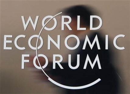 
Attendees are reflected behind a logo at the congress centre of the Alpine resort of Davos, the venue of the World Economic Forum (WEF), January 31, 2010. REUTERS/Christian Hartmann
