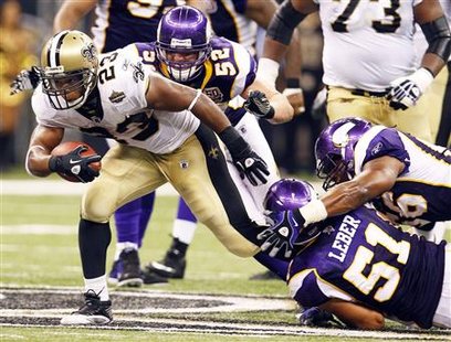 
New Orleans Saints running back Pierre Thomas (23) rushes over Minnesota Vikings defenders while making a first down during the fourth quarter of their NFL football game in New Orleans, Louisiana September 9, 2010. REUTERS/Sean Gardner
