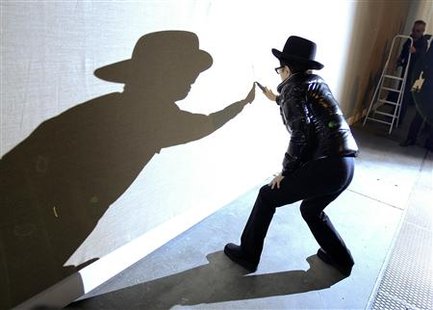 
Artist Yoko Ono slits a canvas that is part of her installation "Heal" during a preview of her exhibition "Das Gift" at the Haunch of Venison gallery in Berlin, September 10, 2010. REUTERS/Thomas Peter
