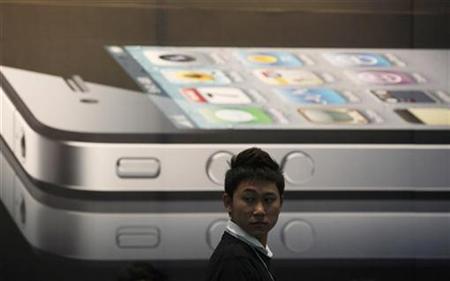 A man stands next to a giant advertisement for an iPhone 4 displayed at a shop in Bangkok September 24, 2010. REUTERS/Chaiwat Subprasom
A man stands next to a giant advertisement for an iPhone 4 displayed at a shop in Bangkok September 24, 2010. REUTERS/Chaiwat Subprasom