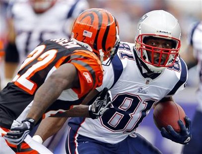 
New England Patriots wide receiver Randy Moss avoids being tackled by Cincinnati Bengals cornerback Johnathan Joseph in the second quarter of their NFL football game in Foxborough, Massachusetts in this September 12, 2010 file photo. REUTERS/Adam Hunger/Files
