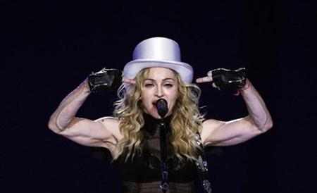 
U.S. singer Madonna gestures as she performs during her Sticky and Sweet tour at the O2 Arena in London July 4, 2009. REUTERS/Luke MacGregor
