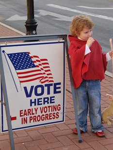 A young child stands in front of a sign directing voters where to cast ballots A young child stands in front of a sign directing voters where to cast ballots