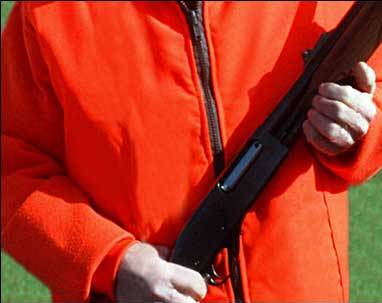 A hunter dressed in a blaze orange jacket.