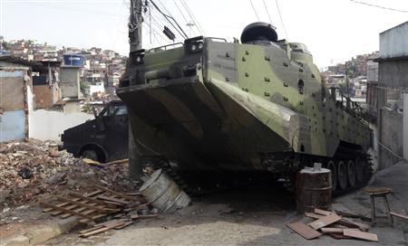 
A Brazilian Army armored vehicle rolls over a blockade during an operation at Alemao slum in Rio de Janeiro November 28, 2010. REUTERS/Bruno Domingos
