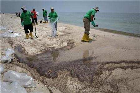 Contract workers shovel oil from a beach impacted by the Deepwater Horizon oil spill in Gulf Shores, Alabama June 16, 2010. REUTERS/Lee Celano
Contract workers shovel oil from a beach impacted by the Deepwater Horizon oil spill in Gulf Shores, Alabama June 16, 2010. REUTERS/Lee Celano