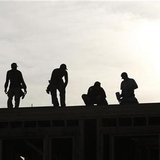 
Workers are silhouetted as they stand on the roof of a building under construction in Los Angeles December 2, 2010. REUTERS/Mario Anzuoni
