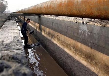 A worker shovels cast-off tailings out of a channel underneath a pipeline that transports crushed mineral ore containing rare earths to a disposal dam near Xinguang Village, located on the outskirts of the city of Baotou in China's Inner Mongolia Autonomous Region in this October 31, 2010 picture. REUTERS/David Gray
A worker shovels cast-off tailings out of a channel underneath a pipeline that transports crushed mineral ore containing rare earths to a disposal dam near Xinguang Village, located on the outskirts of the city of Baotou in China's Inner Mongolia Autonomous Region in this October 31, 2010 picture. REUTERS/David Gray