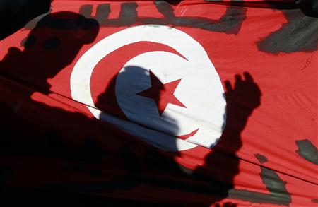 Silhouettes of people are seen on the Tunisian flag during a peaceful demonstration in the Ettadamen suburb of Tunis January 15, 2011.REUTERS/Zohra Bensemra
Silhouettes of people are seen on the Tunisian flag during a peaceful demonstration in the Ettadamen suburb of Tunis January 15, 2011.REUTERS/Zohra Bensemra
