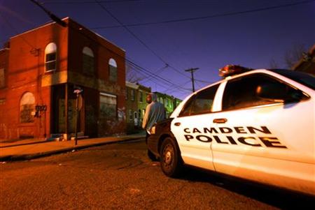 
A unidentified victim of a drive-by shooting who was not hit by the gunfire waits to be questioned by police in Camden, New Jersey March 24, 2005. REUTERS/Shannon Stapleton
