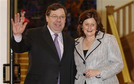 
Brian Cowen, Irish Prime Minister and leader of Fianna Fail, waves to photographers with his wife Mary after winning a vote of confidence from members of his own party in Dublin January 18, 2011. REUTERS/Cathal McNaughton
