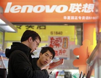 
A customer (L) checks a new laptop with a salesman at a Lenovo shop in Beijing December 13, 2010. REUTERS/Christina Hu
