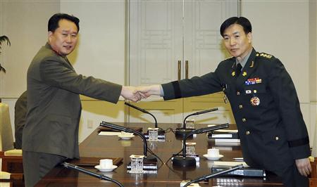 
South Korean Colonel Moon Sang-gyun (R) and his North Korean counterpart Ri Son-kwon pose before their talks at the truce village of Panmunjom in Paju, north of Seoul, February 8, 2011. Military officers from North and South Korea met at their heavily fortified border on Tuesday for the first inter-Korean talks since tension peaked on the peninsula late last year. REUTERS/Defence Ministry/Handout

