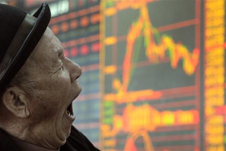 
A man yawns in front of an electronic board showing stock information at a brokerage house in Taiyuan, Shanxi province February 9, 2011. REUTERS/Stringer

