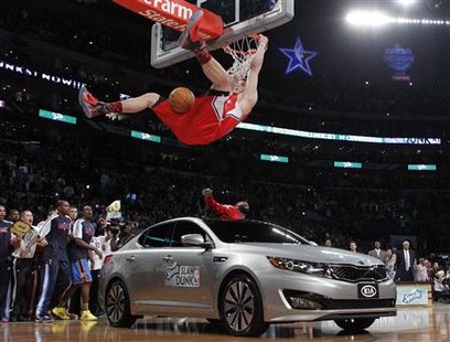 Los Angeles Clippers' Blake Griffin hangs on the rim after jumping over a car while competing in the slam dunk contest during the NBA All-Star dunk contest in Los Angeles, February 19, 2011. REUTERS/Lucy Nicholson
Los Angeles Clippers' Blake Griffin hangs on the rim after jumping over a car while competing in the slam dunk contest during the NBA All-Star dunk contest in Los Angeles, February 19, 2011. REUTERS/Lucy Nicholson