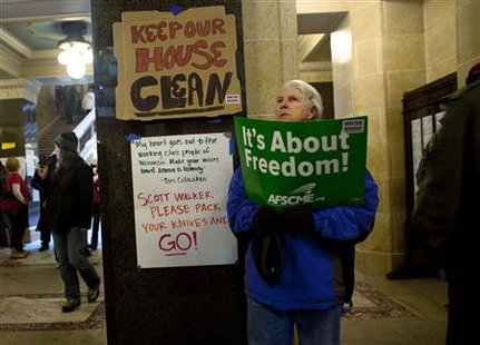 A protester holds a sign on the rotunda floor, on day eight of protests against budget cuts proposed by Wisconsin Governor Scott Walker, at the state Capitol in Madison, Wisconsin February 22, 2011. REUTERS/Darren Hauck
A protester holds a sign on the rotunda floor, on day eight of protests against budget cuts proposed by Wisconsin Governor Scott Walker, at the state Capitol in Madison, Wisconsin February 22, 2011. REUTERS/Darren Hauck