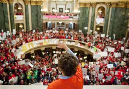 A member of the State Assembly Democrats waves as supporters cheer after the party spoke in the Assembly to voice their opinion against the proposed bill by Republican Governor Scott Walker in Madison, Wisconsin, February 18, 2011. REUTERS/Darren Hauck