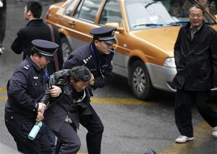 
Police arrest a man in front of the Peace Cinema in downtown Shanghai, after calls for a "Jasmine Revolution" protest, organised through the internet February 27, 2011. REUTERS/Carlos Barria
