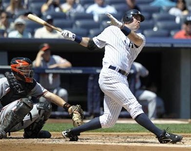 
New York Yankees batter Nick Johnson hits a solo home run in front of Baltimore Orioles catcher Craig Tatum in the first inning of their MLB American League baseball game at Yankee Stadium in New York, May 5, 2010. REUTERS/Ray Stubblebine
