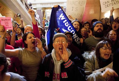 Protestors yell outside of the office of Wisconsin State Governor Scott Walker after the signing of the ceremonial bill, after the Republican-controlled House and Senate eliminated almost all collective bargaining for most public workers, at the state Capitol in Madison, Wisconsin March 11, 2011. REUTERS/Darren Hauck
Protestors yell outside of the office of Wisconsin State Governor Scott Walker after the signing of the ceremonial bill, after the Republican-controlled House and Senate eliminated almost all collective bargaining for most public workers, at the state Capitol in Madison, Wisconsin March 11, 2011. REUTERS/Darren Hauck