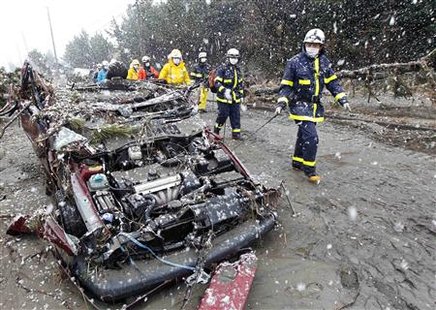 Rescue workers walk past a destroyed car during heavy snowfall at a factory area devastated by an earthquake and tsunami in Sendai, northern Japan March 16, 2011. REUTERS/Kim Kyung-Hoon
Rescue workers walk past a destroyed car during heavy snowfall at a factory area devastated by an earthquake and tsunami in Sendai, northern Japan March 16, 2011. REUTERS/Kim Kyung-Hoon