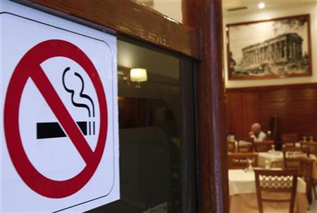 A man eats behind a smoking ban sign in a restaurant-cafe in central Athens, October 18, 2010. REUTERS/John Kolesidis
A man eats behind a smoking ban sign in a restaurant-cafe in central Athens, October 18, 2010. REUTERS/John Kolesidis