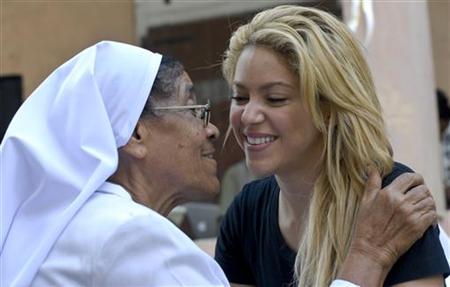 Colombian singer Shakira embraces a nun during a ceremony held in 